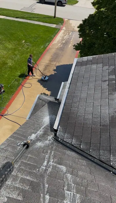 Low pressure roof wash on asphalt shingles, seen from the roofline