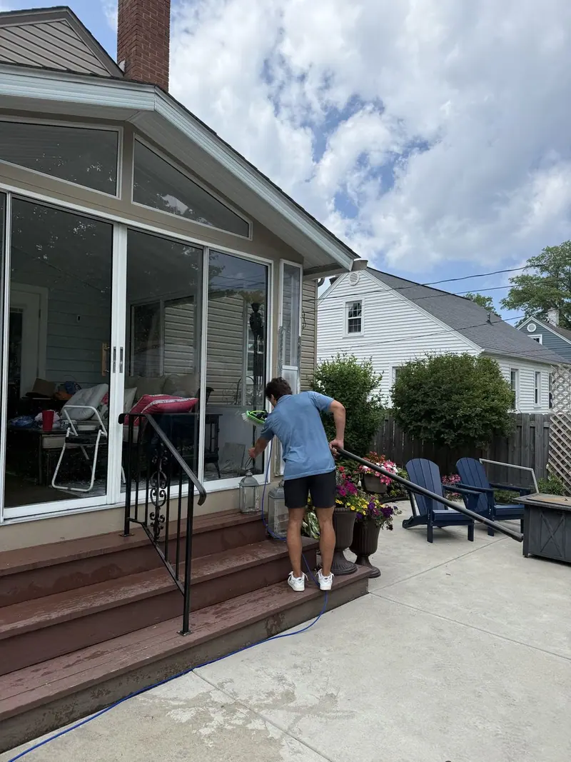 Cleaning the glass and screens on a screened porch from the patio